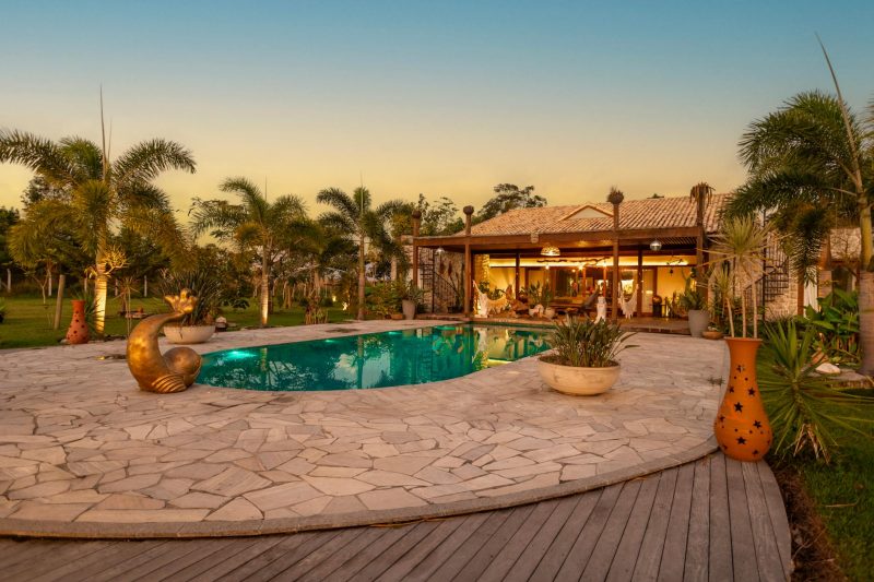 Tranquil backyard with a pool palm trees and a cozy house