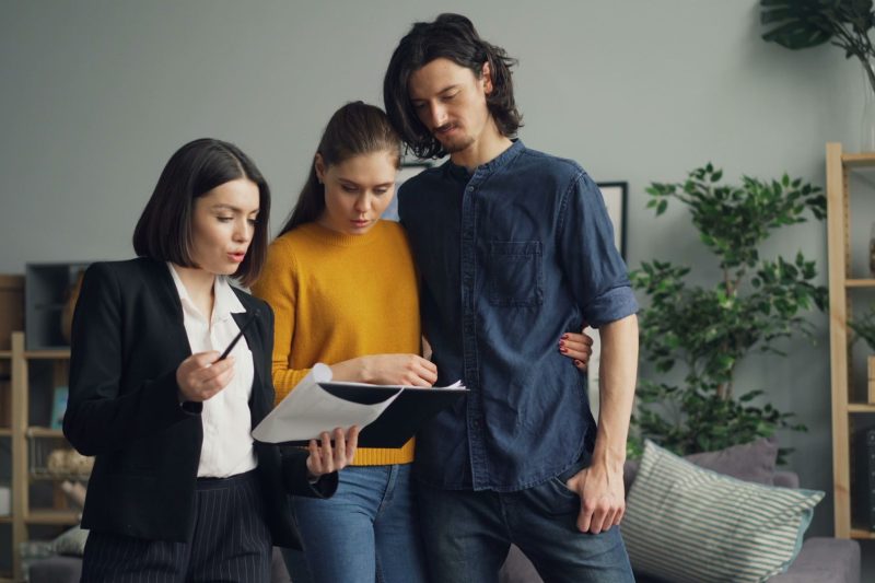 A couple reviewing documents with real estate agent